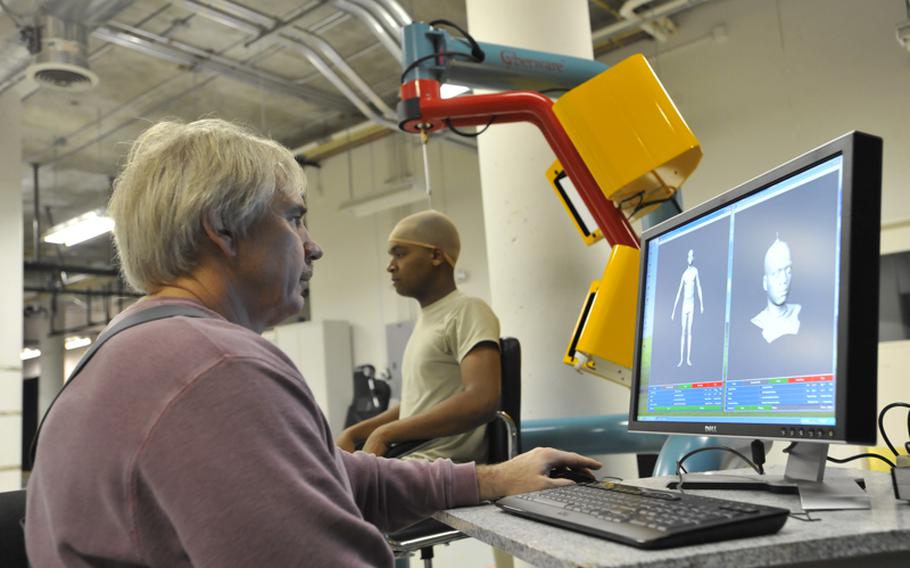 Brian Corner, a scientist at the Natick Soldier Research, Development and Engineering Center in Massachusetts, measures a soldier's head and face using a 3-D scanner.