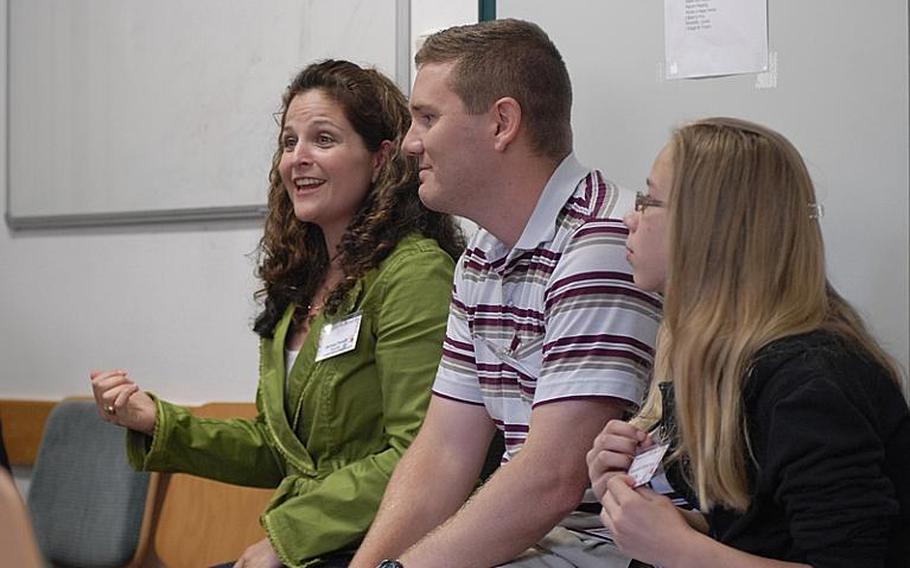 Melissa Pontiff, left, speaks as husband, Mike, and daughter, Dasha, listen at the 2011 European Adoption Symposium in Kaiserslautern, Germany. The Pontiffs have adopted a pair of siblings from the Ukraine and three siblings from Texas.