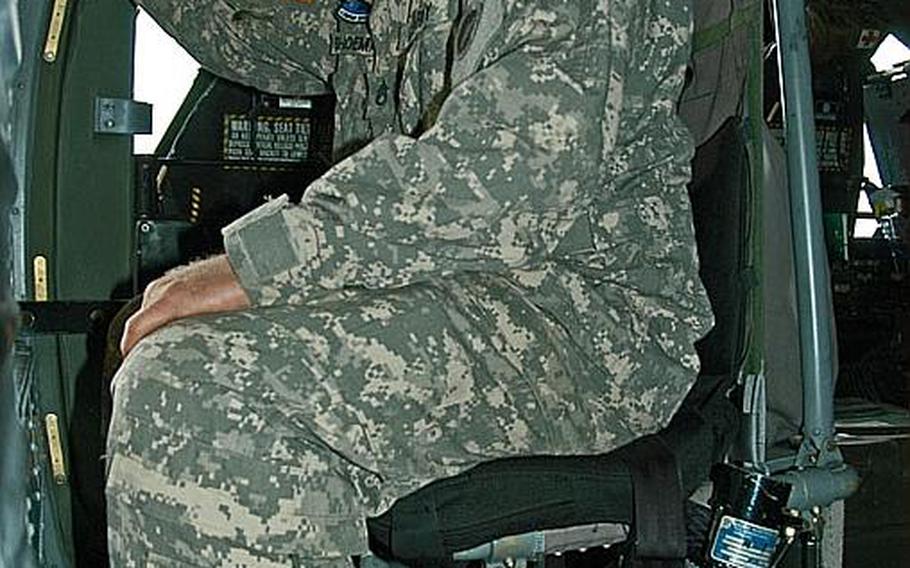 Staff Sgt. Wesley Shoemaker, 33, of Camarillo, Calif., demonstrates how he sits during missions with U.S. Army Aviation Detachment Japan. Shoemaker is a crew chief with the detachment.