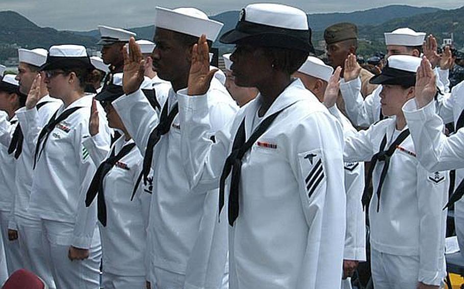 Seaman Pamela Adjibodou, who moved from West Africa to Boston, Mass., in 2006 and is stationed at Marine Corps Air Station Iwakuni, recites the Oath of Allegiance on Friday as she becomes a U.S. citizen.