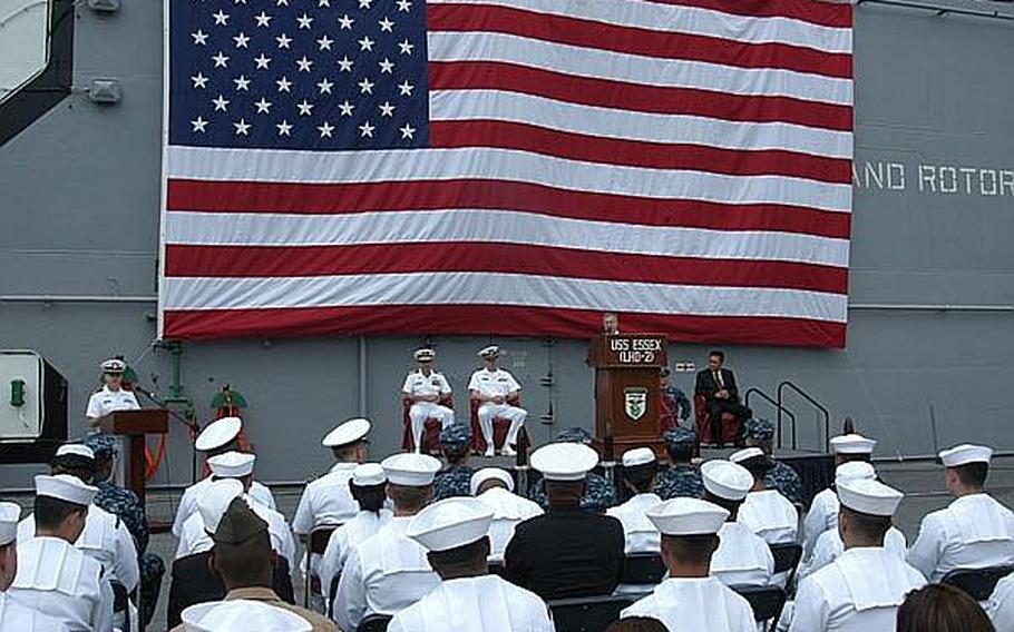 Kenneth Sherman, an official from the U.S. Citizenship and Immigration Services, speaks to applicants from the flight deck of the USS Essex.