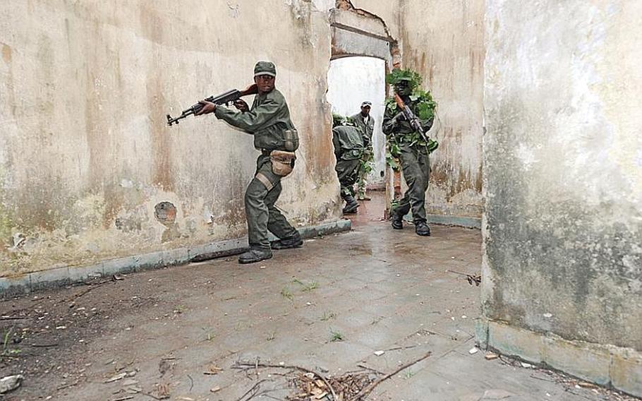 Congolese soldiers assigned to the Congolese Light Infantry Battalion execute a training scenario on how to clear a building at Camp Base in Kisangani, Congo, May 5, 2010. The soldiers are attending a seven-month program to obtain training in field sanitation, gender-based violence, basic military principles and military professionalism as part of Operation Olympic Chase, an operation led by U.S. Africa Command.