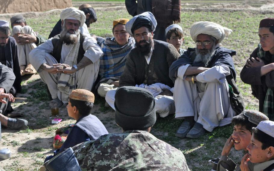 Elders in the village of Kor Jalal, located in southern Logar province, listen to Bazudin Mohmand (in dark cap at bottom), commander of an Afghanistan National Army unit on joint patrol with a U.S. Army platoon, during an informal shura last week.
