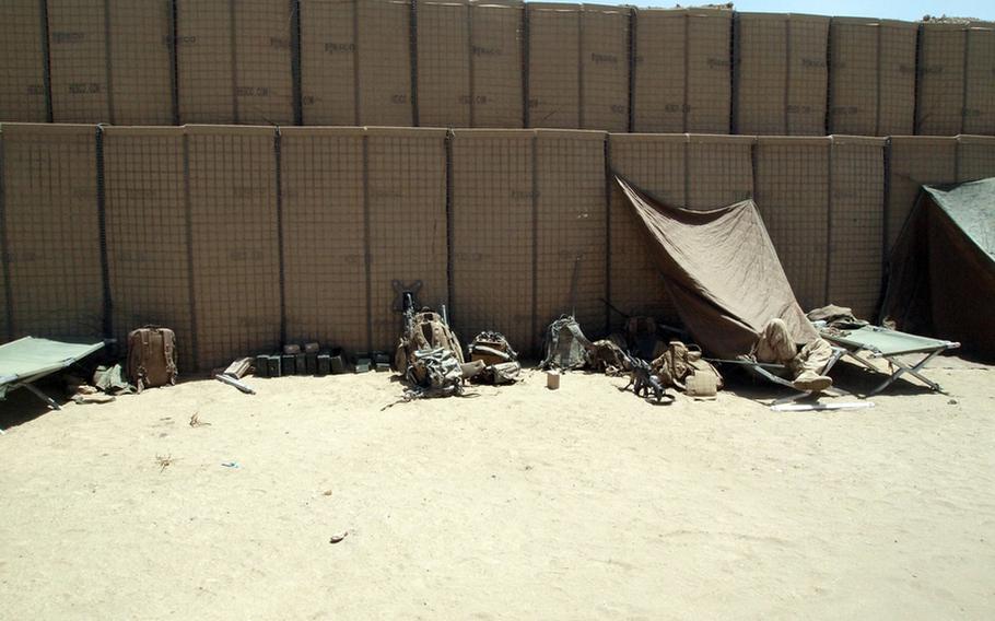 A Marine takes a nap in the afternoon sun during a break from a work detail at Patrol Base Salaam Bazaar. Marines established the base May 16 by building a perimeter of Hesco barriers, wire and fabric baskets typically filled with rock and sand. By Thursday they had added a bunker and only the barest of amenities, including two outhouse stalls, tubes to urinate into, a space for showering and few tents.