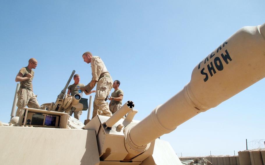 Sgt. Frank Valli, Lance Cpl. David Willsie, Sgt. Robert Glace and Pvt. Mark Martinez, the crew of the Abrams main battle tank Freak Show, perform maintenance on their tank May 19, a day after gunning down an insurgent trying to escape on a motorcycle after attacking Marines.