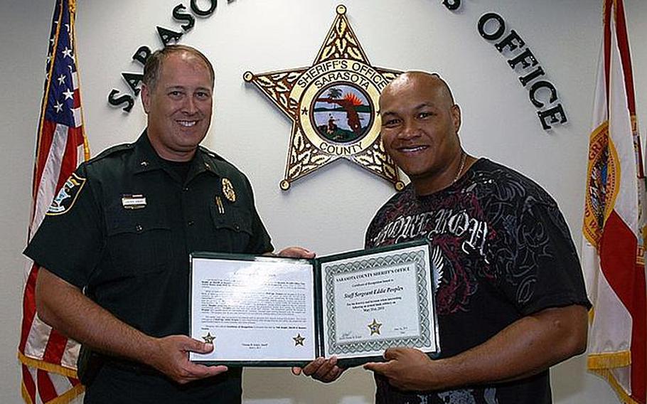 Sheriff Tom Knight,left, presents a Certificate of Recognition to Army Staff Sergeant Eddie Peoples for disarming and subduing the man who robbed a Bank of America, in Sarasota, FL, on Tuesday.
Courtesy Sarasota County Sheriff's Office