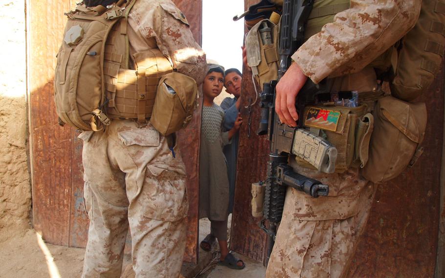 Marine Sgt. Randy Williamson, right, a squad leader from Stroudsburg, Pa., and an interpreter talk to some young boys early in the morning on May 27 while trying to find an English-speaking shopkeeper they know lives in the area. Williamson is the leader of 1st Squad, 3rd Platoon, Company I, 3rd Battalion, 2nd Marine Regiment.