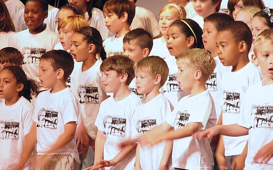 Wearing commemorative T-shirts, the school's pupils sing their farewell to Mark Twain Elementary School in Heidelberg, Germany, on Friday. The school is closing later this month after 59 years.