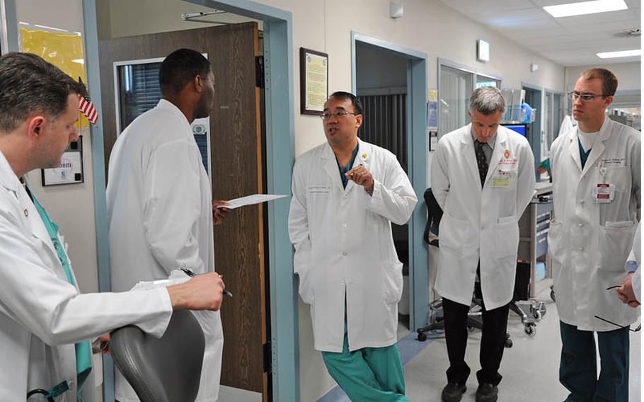 Dr. (Lt. Col.) Raymond Fang, center, talks to Dr. (Capt.) Derric Whiteside, second from left, about a patient's condition during the morning rounds in the intensive care unit at Landstuhl Regional Medical Center on May 20. Fang is leaving the LRMC after seven years.