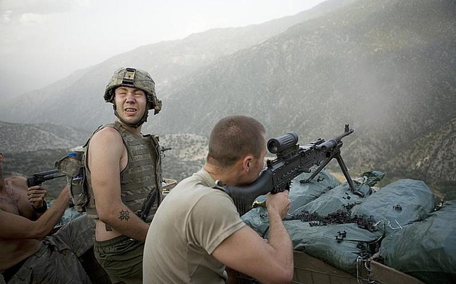 Spec. Misha Pemble-Belkin, left, and fellow soldiers from Battle Company, 173rd Airborne Brigade are shown here during a firefight at now-defunct Outpost Restrepo in Afghanistan's Korengal Valley in 2008. 