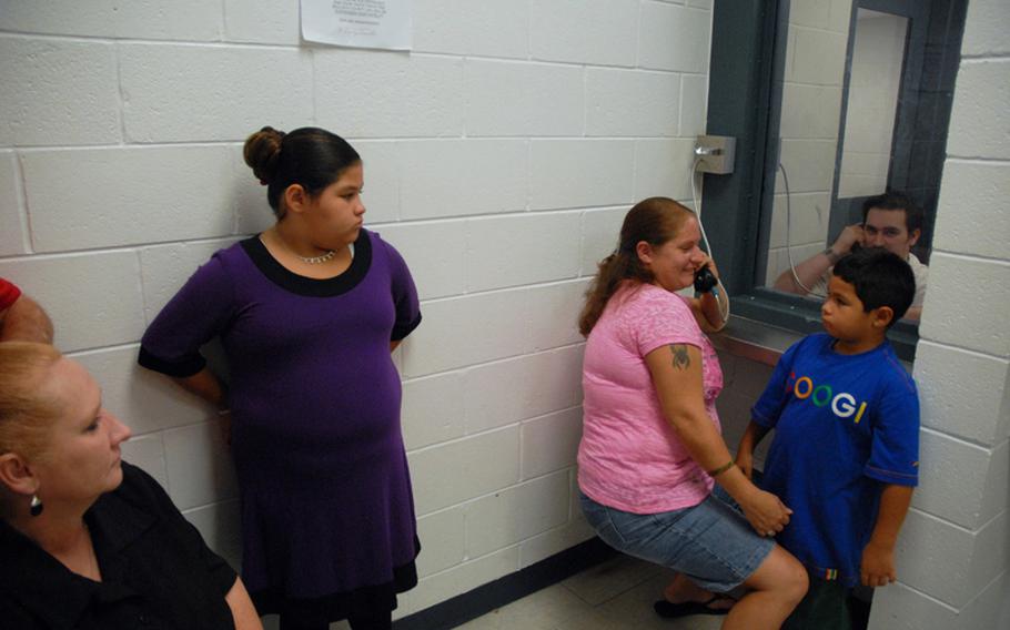 Former Army Sgt. Robert Quinones talks to his sister during family visiting hours in July at the Bulloch County Jail in Statesboro, Ga., where he is being held as a federal prisoner for a hostage incident at the hospital on nearby Fort Stewart. His family, including his sister&#39;s two children and his parents, visit him often.