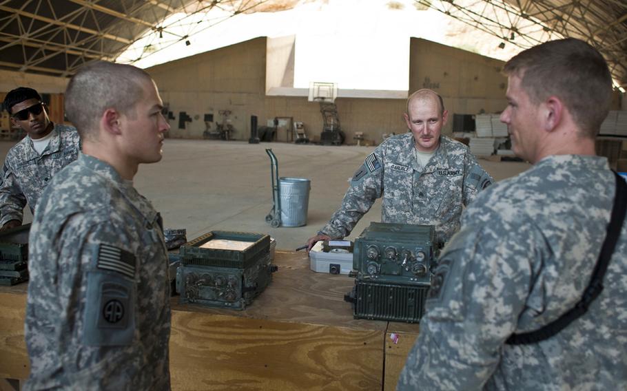 Sgt. William Carlisle, second from right, of St. Augustine, Fla., processes broken laptops, printers and GPS systems on Aug. 15, 2011, that were turned in at the Redistribution Property Assistance Team yard at Al Asad Air Base in Al Anbar province, Iraq. As U.S. forces draw down, Carlisle helps facilitate the collection and shipping of goods here that are leaving Iraq.