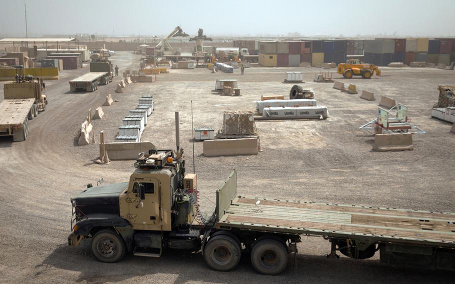 Armored cargo trucks prepare to load cargo at the largest U.S. Army Central Shipping and Receiving Point yard in Iraq at Sather Air Base outside Baghdad on Aug. 18, 2011. Trucks will be loaded with goods brought to Sather from bases that are drawing down and closing and transported to Contingency Operating Base Adder, an enduring U.S. base in Tallil, Iraq.