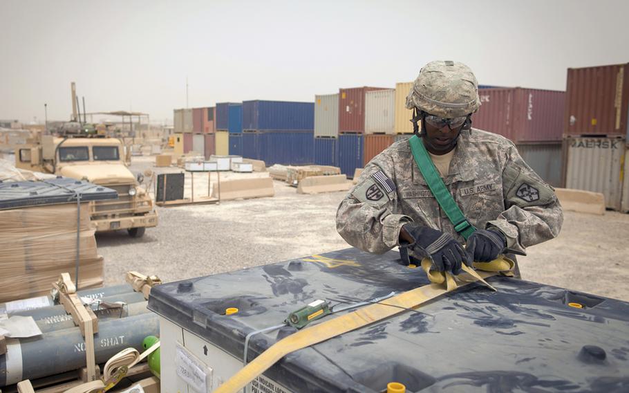 Sgt. Walter Washington, of Eastern Shore, Md., with the 68th Transportation Company, 142nd Combat Sustainment Support Battalion, cinches down cargo that came from closing bases throughout Iraq at Sather Air Base's Central Receiving and Shipping Point yard. The items are headed to Contingency Operating Base Adder, a U.S. Base in Tallil, Iraq, to support the enduring operation there.