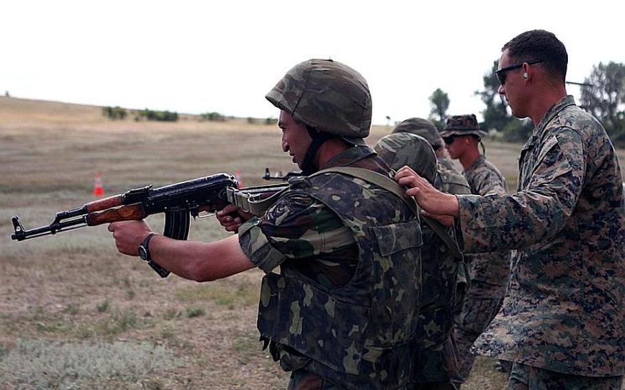 Cpl. James A. Scarborough, a member of the Marines Black Sea Rotational Force, helps two Azerbaijani soldiers build proficiency in close-quarters style shooting at the Babadag Training Area in Romania. The Black Sea Rotational Force 11 trained with Azerbaijan?s Operational Capabilities and Concepts Battalion in August as part of an effort to develop interoperability in counterinsurgency and peacekeeping operations in a combined-forces environment. Since April, Marines have been working with partner militaries from Black Sea, Balkan and Caucasus regions.