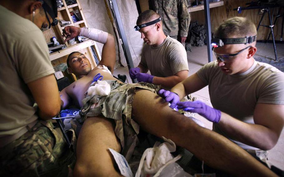 Spc. Victor Bardales is treated for shrapnel wounds by medics Sgt. Joe Tapia, left, Sgt. Miles Boggs and Pfc. Nicholas Seay from a rocket-propelled grenade attack in May, near Combat Out Post Nalgham, Afghanistan.
Laura Rauch/Stars and Stripes