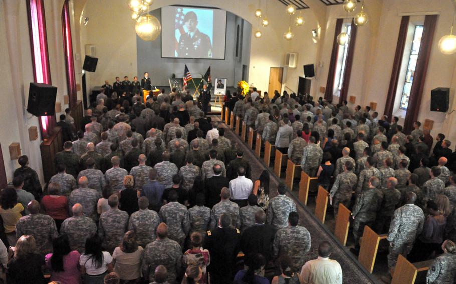Mourners at a memorial service Tuesday for Sgt. 1st Class Danial "Slim" Adams, who was posthumously promoted to master sergeant, stand for the playing of taps. Adams, 35, of Portland, Ore., died Sept. 13 of wounds suffered during an intense firefight with insurgents while on patrol in Wardak province in eastern Afghanistan. A memorial for him was held Tuesday at Panzer Kaserne Chapel in Böblingen.