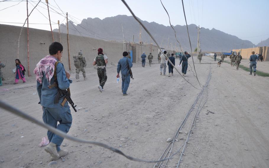 Afghan policemen and American soldiers walked through a Kandahar City neighborhood near the former home of Taliban leader Mullah Omar. Security has recently improved in this former insurgent stronghold.