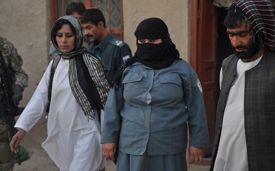 Female security officers walk through a courtyard during a joint raid with American soldiers in Kandahar City this September.