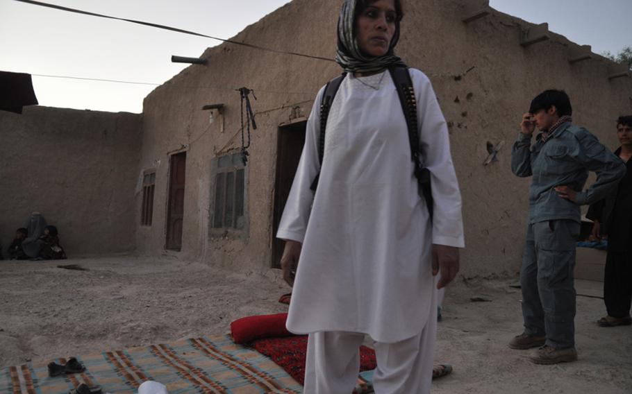 An Afghan security officer scans a courtyard during a raid in Kandahar City.