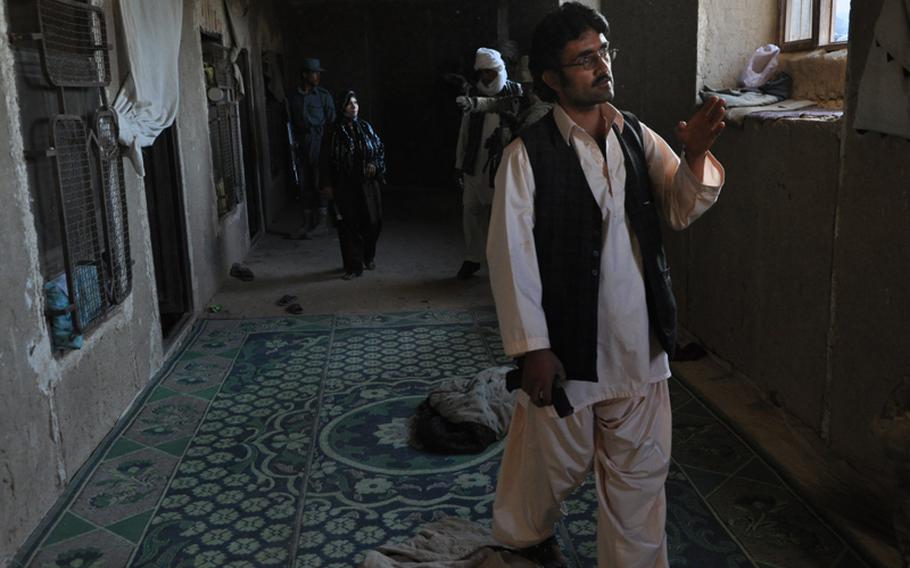 An Afghan security officer walks through a sunken hallway during a house search in northwestern Kandahar City.