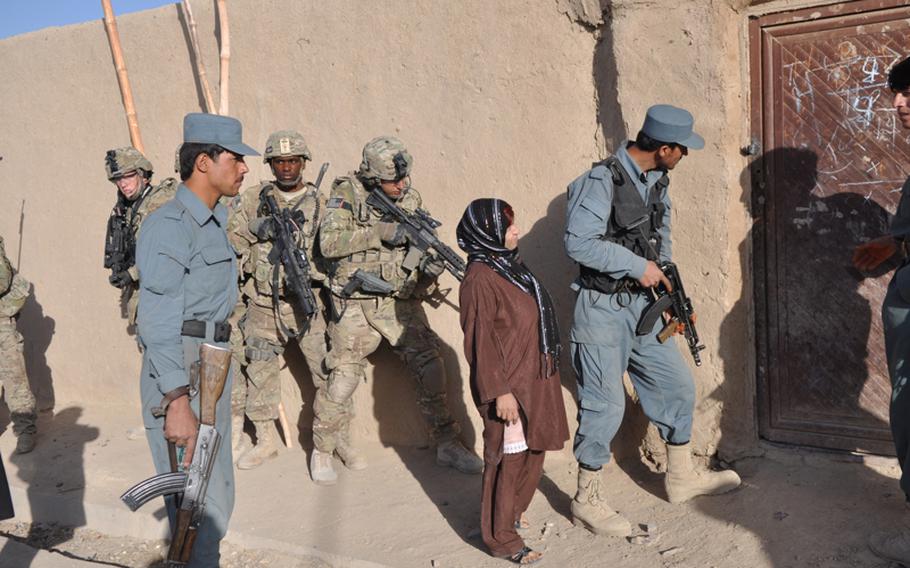 U.S. soldiers with the 3rd Platoon, 561st Military Police Company, prepared to enter a compound in northwestern Kandahar City with Afghan police officers in mid-September.