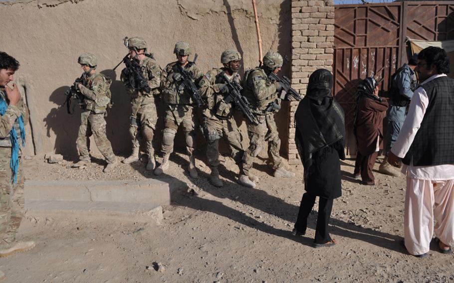 Afghan police officers and U.S. soldiers with 3rd Platoon, 561st Military Police Company, prepared to enter a compound in northwestern Kandahar City in mid-September.