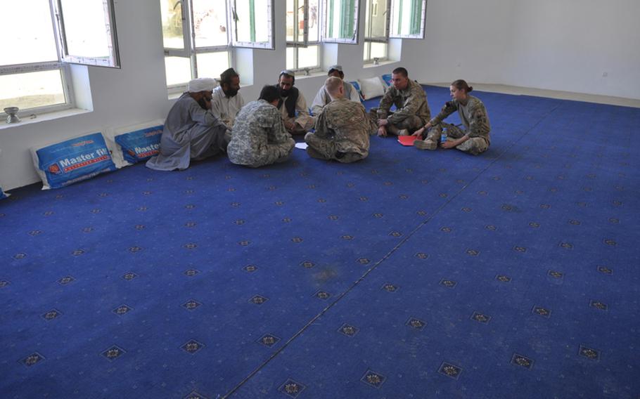 First Lt. Anna Kowalk, at right, and her commander, Capt. Aaron Cross, of Apache Troop, 1-10 Cavalry, third from right, met with elders in Kandahar City in mid-September. ''Security is definitely better,'' one local leader said. ''But if the U.S. leaves, the Taliban will immediately return.''