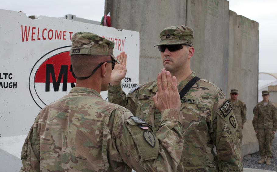 Col. Todd Wood reenlists Staff Sgt. Brian Beem, the nighttime battle noncommissioned officer for 5th Squadron, 1st Cavalry Regiment, who lost part of his right leg in a bomb blast in Iraq in 2006.