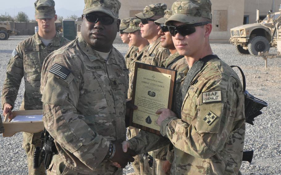 Lt. Col. Patrick Stevenson, left, team commander of the 2nd Special Troops Battalion, 2nd Brigade Combat Team, 4th Infantry Division, awards a Combat Action Badge to Pfc. Joshua Carrington last month at Combat Outpost Pusht Rod in western Afghanistan. Carrington, 20, of Des Moines, Iowa, survived three IED blasts in the span of 10 days earlier this year.
Martin Kuz/Stars and Stripes
