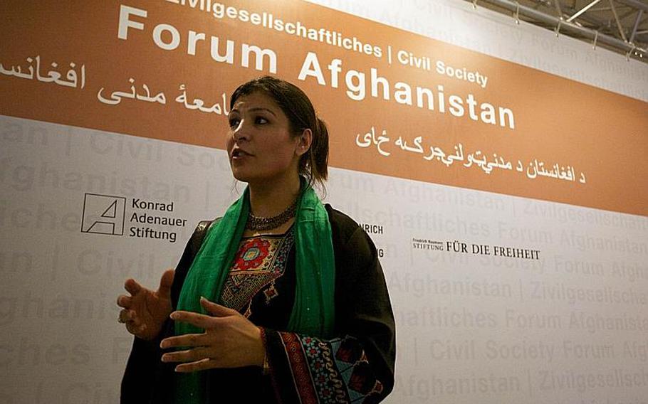 Horia Mosadiq, an Afghan researcher for Amnesty International, speaks with an Afghan journalist Saturday following addresses by German Foreign Minister Guido Westerwelle and Afghan Foreign Minister Zalmay Rasoul at a civil society forum in Bonn, Germany.