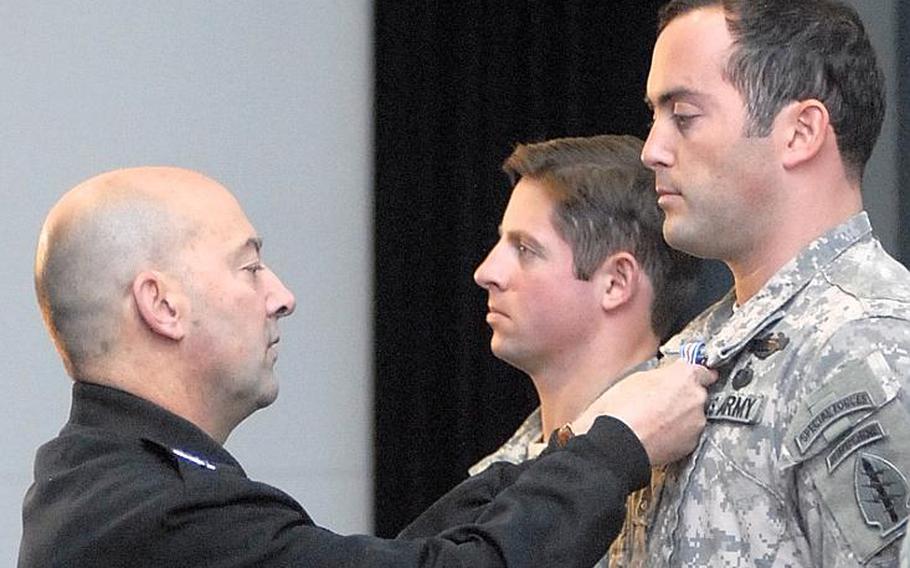 Adm. James Stavridis, head of the U.S. European Command, pins the Silver Star on Sgt. 1st Class McKenna L. Miller during a ceremony Dec. 6, 2011, on Patch Barracks in Stuttgart, Germany. In the background is Army Capt. David G. Fox, who also received the Silver Star. The men received the medal for courage under fire in Afghanistan. A third Silver Star recipient, Staff Sgt. Matthew Gassman, declined to be photographed.