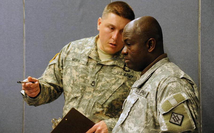Sgt. 1st Class Jose Mora, left, and Staff Sgt. Kwabena Kyeremeh of U.S. Army Europe Emergency Management Assessment Team discuss how Staff Sgt. Tim Butler and Sgt. David Larkin, both of the 773rd Civil Support Team performed during a HAZMAT exercise in Kaiserslautern, Germany, on Dec. 6.