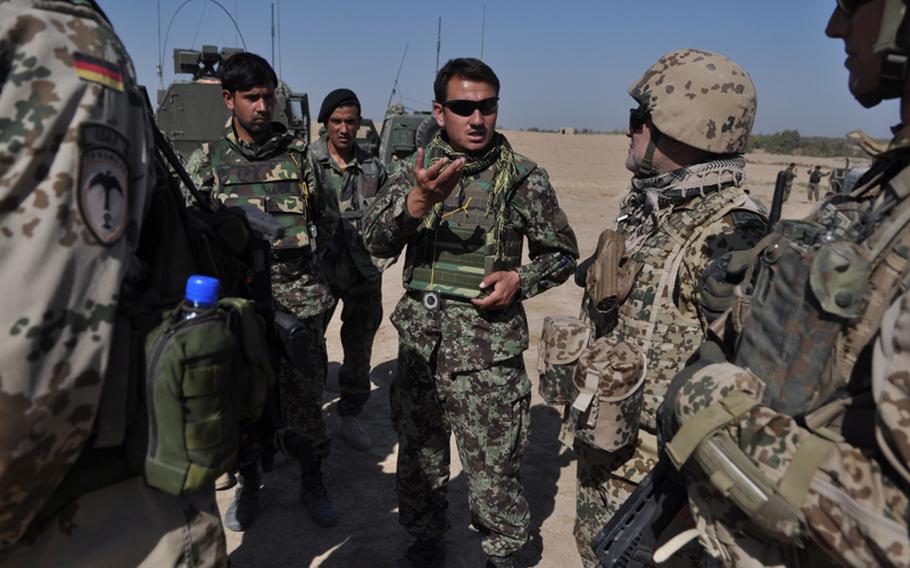 An Afghan National Army officer talks with German and Belgian troops after a patrol in the Char Dara district of Kunduz province in October. "There&#39;s quite some improvement," a Belgian training officer said. "When I was here in 2009, we&#39;d look at a map and I&#39;d say &#39;OK, it&#39;s one kilometer away.&#39; And they&#39;d look at me and say &#39;What&#39;s a kilometer?&#39; So they&#39;re getting better, slowly."