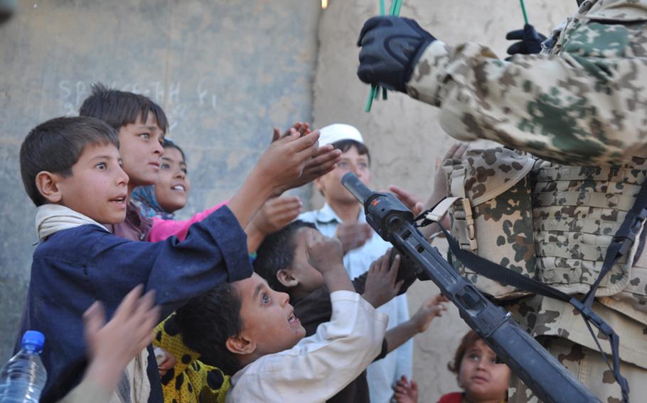German soldiers hand out candy during a patrol through the Char Dara district, southwest of Kunduz city, Afghanistan.
