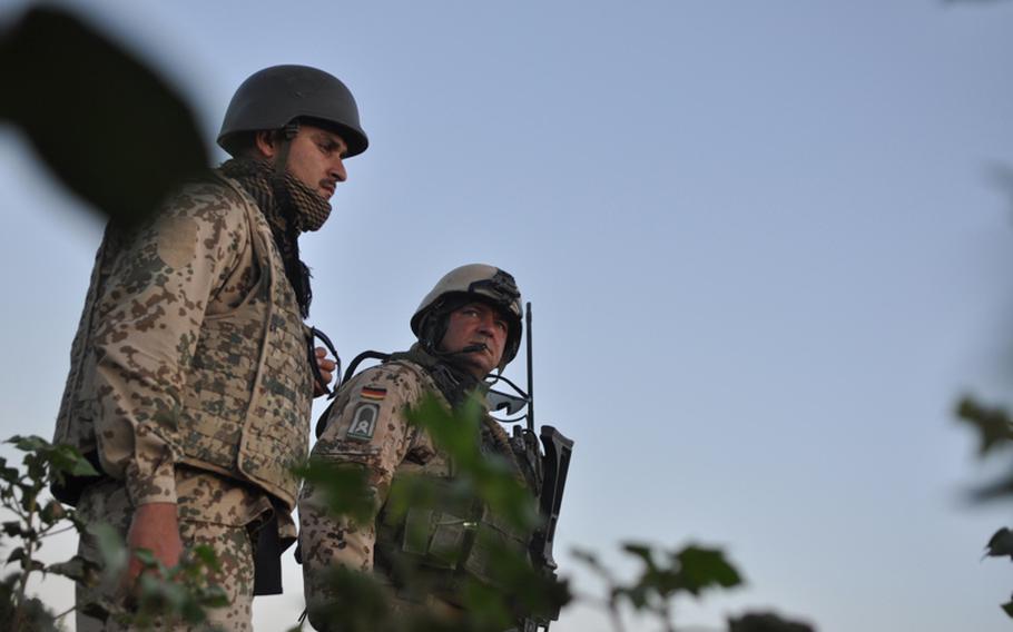 Master Sgt. Andreas Kaitschik, right, leader of Germany's Platoon B, 2nd Infantry Company, Task Force Kunduz, stands with an Afghan translator during a patrol through a cotton field in northern Afghanistan.