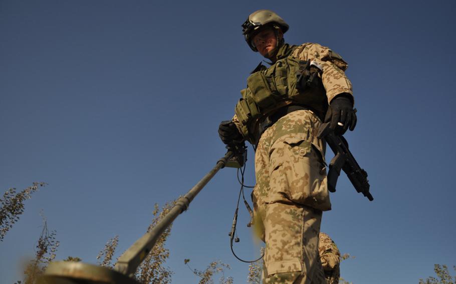 A German explosive ordnance disposal soldier sweeps for bombs along a road in the Char Dara district, Kunduz province, Afghanistan.