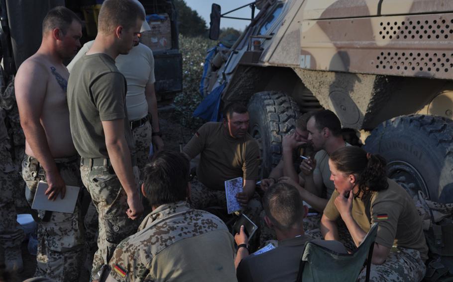 German Master Sgt. Andreas Kaitschik, center, leader of Platoon B, 2nd Infantry Company, Task Force Kunduz, gathers his soldiers during a patrol in the Char Dara district, Afghanistan, to discuss an upcoming raid.