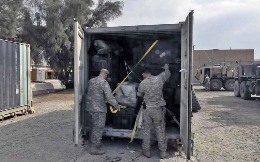 Soldiers with the 1st Cavalry Division's 1st Brigade load some of the last cargo containers at Camp Echo, one of the last U.S. bases to close in Iraq this month. The brigade's community was initially told the soldiers would be coming home early. But a change of plans means most of them will spend the final six months of their tour in Kuwait, which has angered some soldiers and family members.