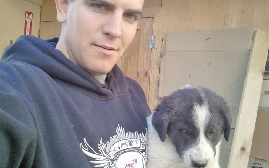 SPC Kevin Shumaker with a ''base'' puppy. Shumaker loved dogs, his mother said, and according to the investigation into his death from rabies, he fed and otherwise interacted with dogs on Combat Outpost Base Chamkani, a violation of a longstanding CENTCOM general order. But the order was also ignored by the base command, the investigation showed. Keeping dogs as pets has been common on U.S. bases in Afghanistan because they improve morale, troops say, and sometimes improve security.