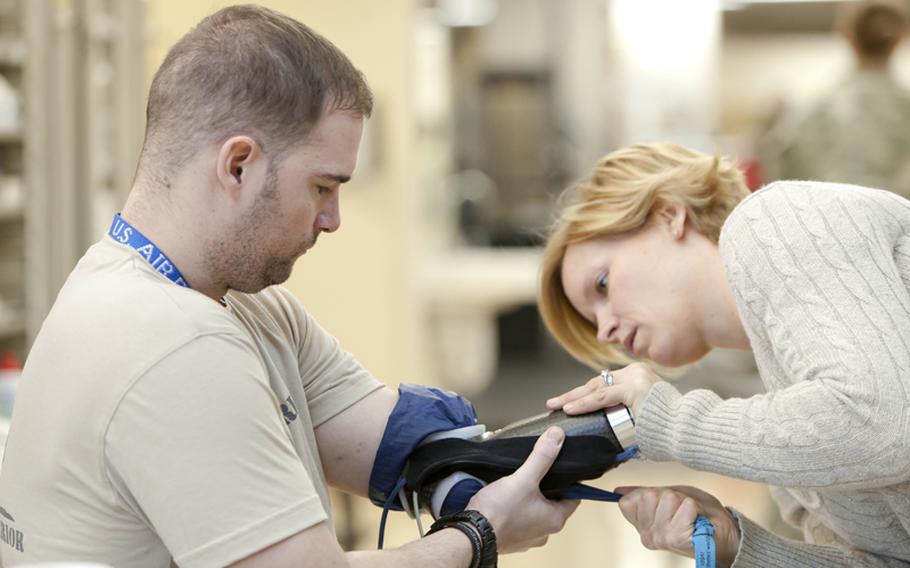 Air Force Tech. Sgt. Joe Deslauriers puts on the modular prosthetic limb created by Johns Hopkins University's Applied Physics Laboratory. Deslauriers is helping APL researchers to advance the arm in hopes that it will soon be ready for the public.