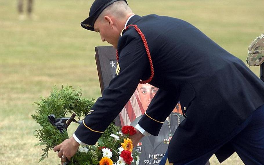 A soldier with the 172nd Separate Infantry Brigade lays a wreath by a temporary memorial for Sgt. Jerry D. Reed II, one of 10 soldiers with the brigade who died during the unit's deployment to Afghanistan. The recognition was part of a Thursday uncasing ceremony for the brigade in Grafenwöhr, Germany.