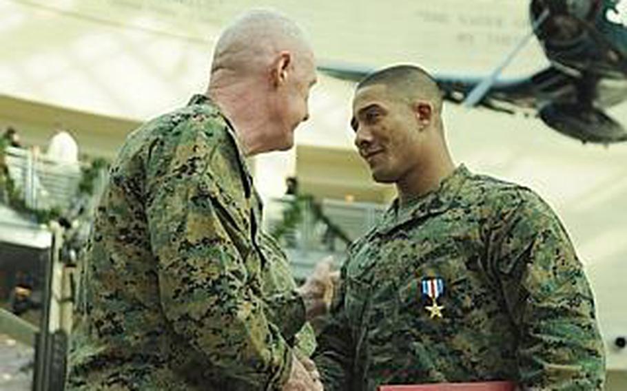 Lt. Gen. Richard Mills, deputy commandant for combat development and integration, congratulates Gunnery Sgt. Verice Bennett after presenting him with a Silver Star at the National Museum of the Marine Corps in December.