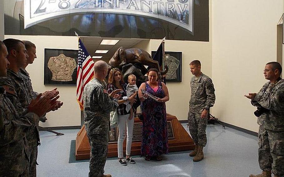Lauri Turner, center right, the mother of Spc. Jacob Andrews, stands with Andrews&#39; girlfriend, Ashley Mercante, and the couple&#39;s baby as she receives a plaque from 3rd Brigade Combat Team Commander Col. Samuel Whitehurst. Andrews, who committed suicide in April 2011, was the only soldier in his unit who did not receive a combat infantryman badge at the time, so the unit set up the ceremony to posthumously award the badge and plaque to his family. Three soldiers who served with Andrews also attended the ceremony.