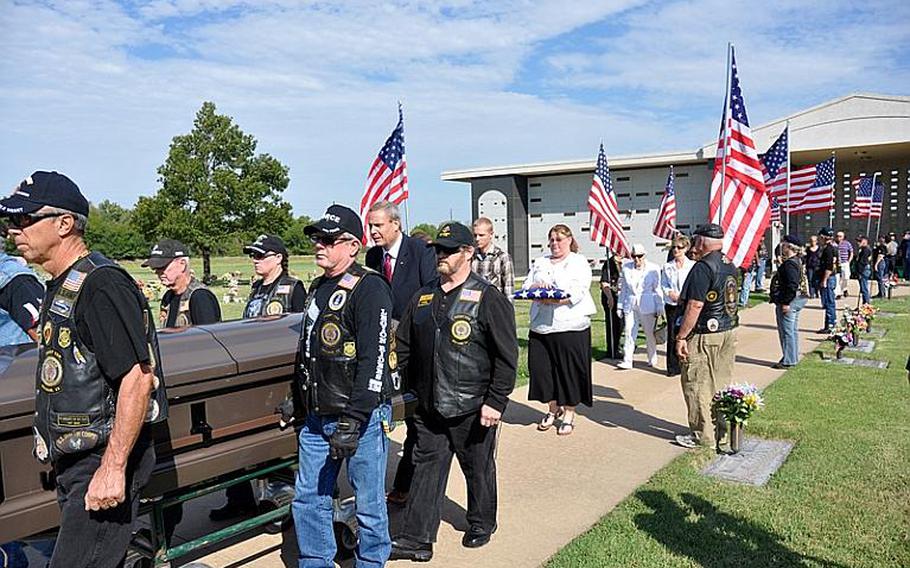 Angela Foster, in white with the folded flag, walks behind the casket of former Army Sgt. Patrick Dunagan at his funeral in Wichita, Kan., last week. Dunagan died homeless and without family connections, so Foster, a Gold Star Mother, stood in for family at his funeral.