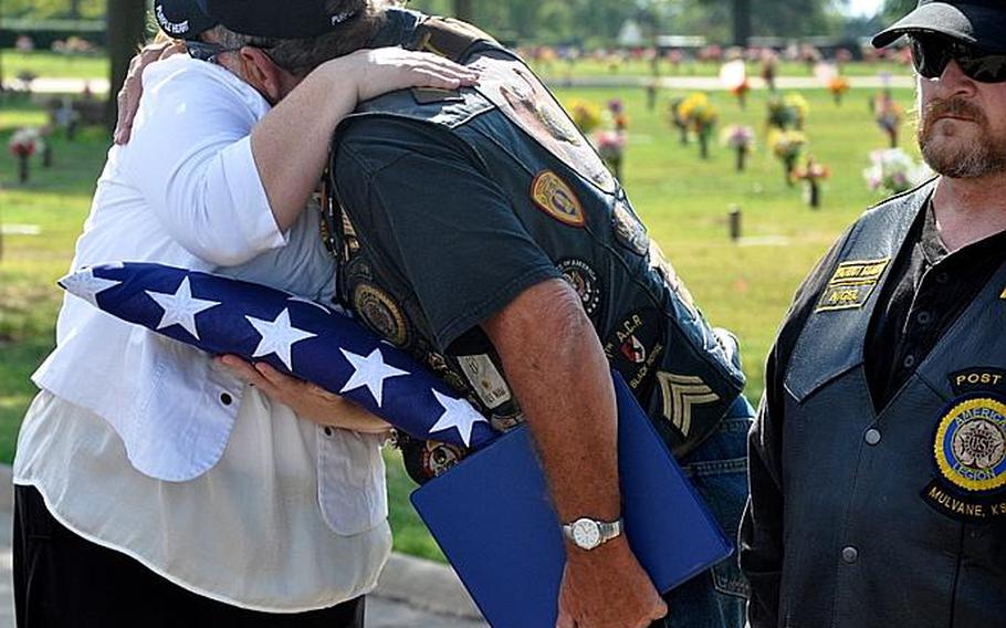 After a funeral for a homeless veteran, Angela Foster gets a hug from the veteran who gave the eulogy. Foster, a Gold Star Mother, was there to stand in for family and accept the flag in honor of the veteran.