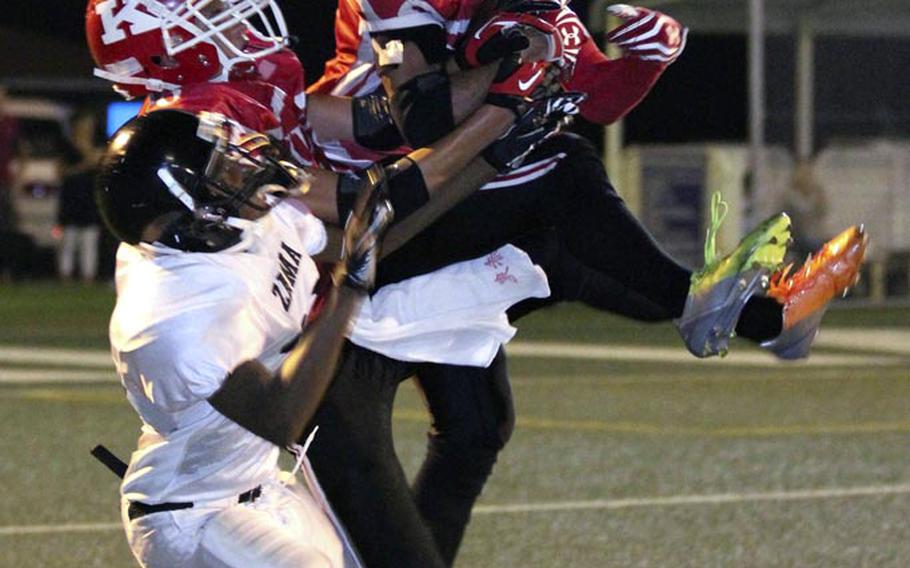 Nile C. Kinnick defender Quinton Holden outreaches teammate Marcel Holden and Zama American's Raymond Bestor for an interception during Friday's DODDS Japan-Kanto Plain Association of Secondary Schools football game at Yokosuka Naval Base, Japan. 