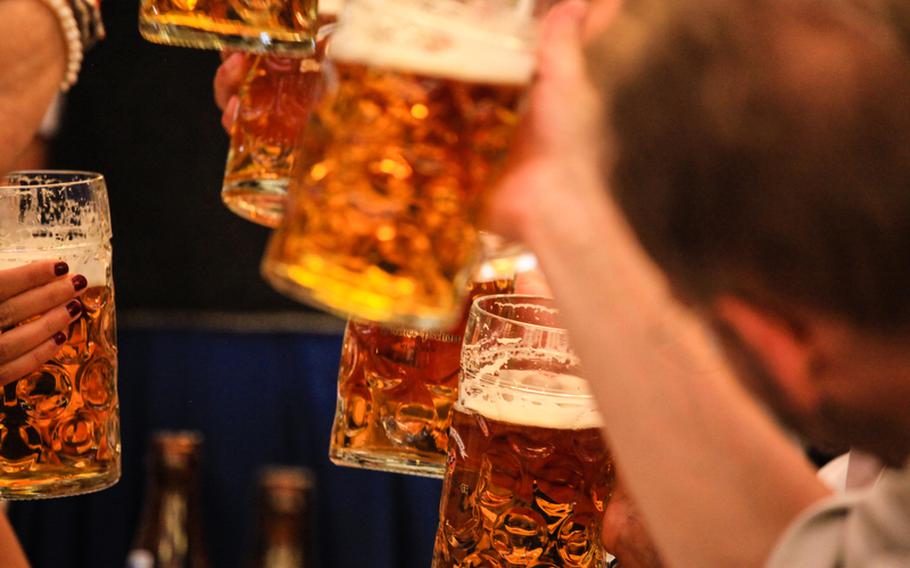 After many hours of waiting, Oktoberfest revelers clink their first liter-sized glasses of beer.