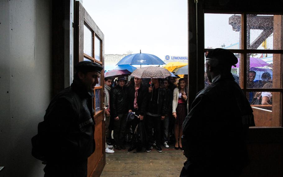 While revelers party inside, thousands more wait in the rain to get into Oktoberfest&#39;s 14 tents.