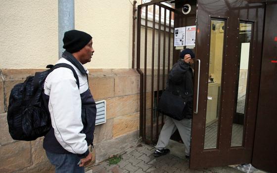 A worker waits for a colleague to enter Kleber Kaserne, a U.S. Army base in Kaiserslautern, through an automated pedestrian gate. The first man got through fine; after having trouble with the fingerprint scanner, the second man pressed a button to call a guard who buzzed him in.